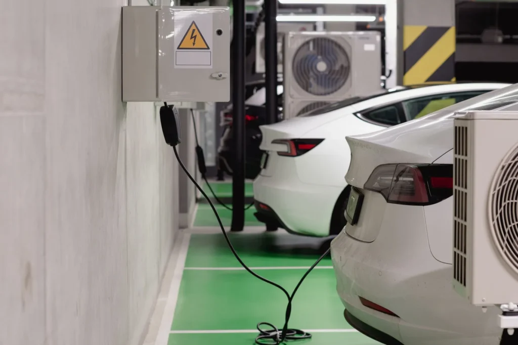 Borne de recharge murale installée dans un garage résidentiel, raccordée à un véhicule électrique