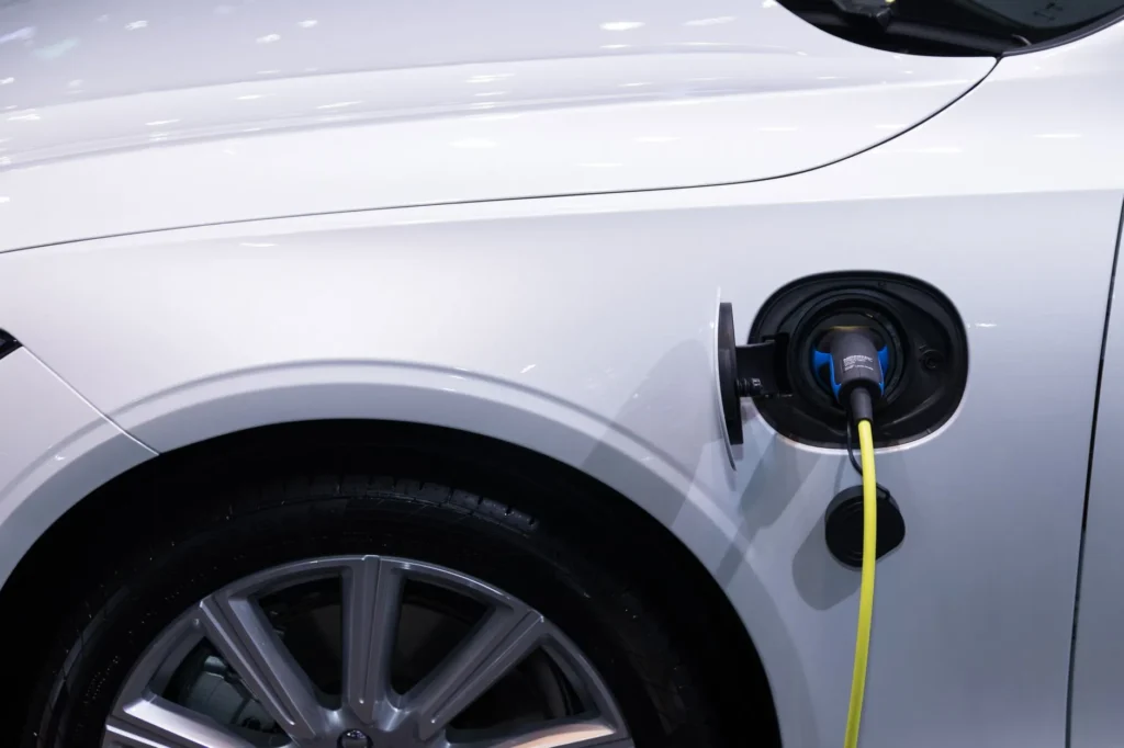 Borne de recharge publique en centre-ville, branchée à un véhicule électrique